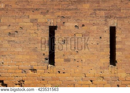 A Loophole In An Old Stone Wall. The Fortification Stone Wall Of An Ancient Castle With Loopholes. B