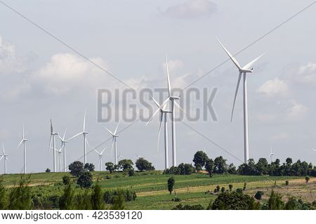 Rear View Man Engineer Wearing Personal Protective Equipment Working In Wind Turbine Farm Background