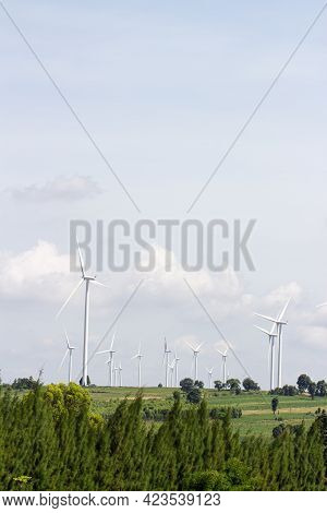 Rear View Man Engineer Wearing Personal Protective Equipment Working In Wind Turbine Farm Background