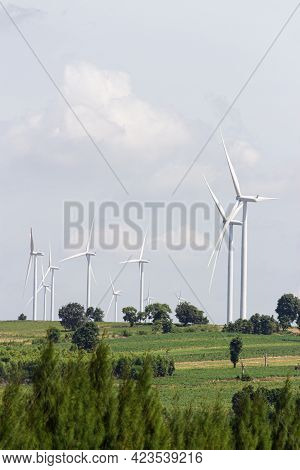 Rear View Man Engineer Wearing Personal Protective Equipment Working In Wind Turbine Farm Background