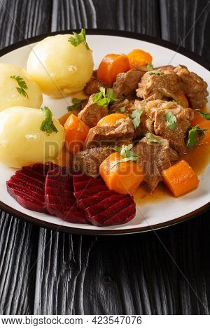 Beef Stew With A Side Dish Of Boiled Potatoes And Pickled Beets Close-up In A Plate On The Table. Ve