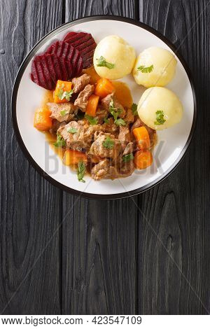 Beef Stew With A Side Dish Of Boiled Potatoes And Pickled Beets Close-up In A Plate On The Table. Ve