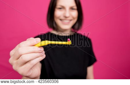 Beautiful Happy Young Woman With Single Tufted Toothbrush On Blank Pink Background