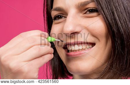 Beautiful Happy Young Woman Using Interdental Brush On The Pink Background
