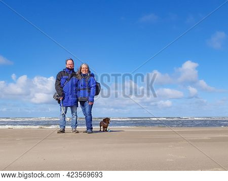 Happy Mature Couple, Mexican Woman And A Dutch Man With Their Brown Short Hair Dachshund Enjoying Th