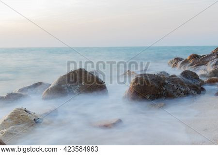 A Slow Shutter Shot Of The Blue Sea Current Beside The Beach In Summer.