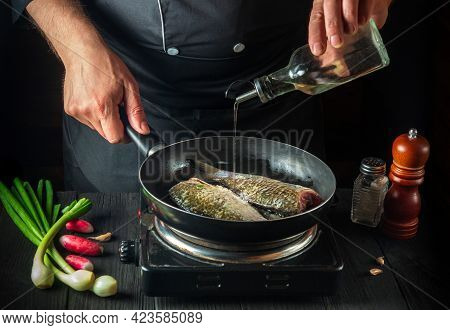The Chef Prepares Fresh Fish In A Pan With Oil. Preparation For Cooking Fish Food. Working Environme