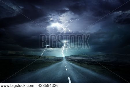 Extreme Weather Conditions. An Empty Landscape With A Road Leading Into A Powerful Thunderstorm With