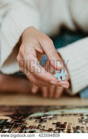 Woman putting together a jigsaw puzzle during self quarantine