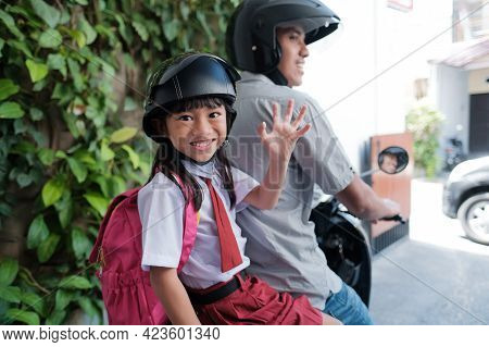 Father Taking His Daughter To School By Motorcycle In The Morning