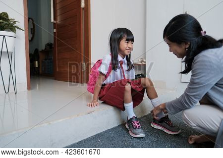 Mother Help Her Daughter To Wear A Shoes In The Morning