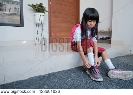 Primary Student Preparing To Go To School In The Morning