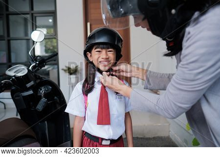 Mother Taking Her Daughter To School By Motorcycle In The Morning