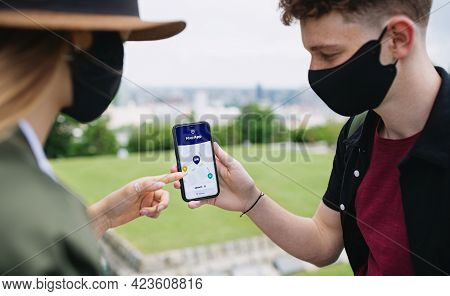 Young Couple Travelers With Smartphone Looking For Accomodation In City On Holiday, Coronavirus Conc