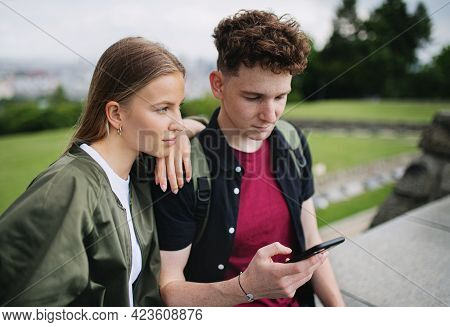 Young Couple Travelers In City On Holiday, Using Smartphone.