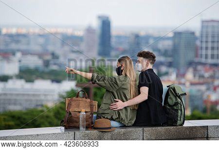 Rear View Of Young Couple Travelers With Map In City On Holiday, Coronavirus Concept.