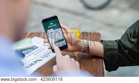 Unrecognizable Couple Travelers With Smartphone Looking For Accomodation In City On Holiday.