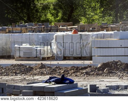 There Are Many Building Materials On The Construction Site. The Curbstone Is Stacked In Piles. The P
