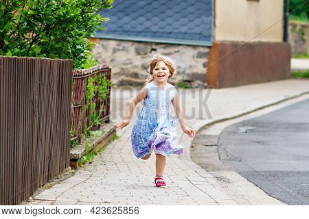 Happy Little Toddler Girl Running On Street In The City, Outdoors. Funny Preschool Child Hild Having
