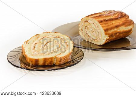 Slices Of The Swiss Roll With Buttercream Filling On Glass Saucer Against The Rest Part Of Roll On D