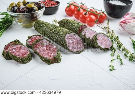 Traditianal Fuet Sausage In Herbs With Ingredients On White Textured Background.