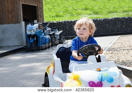 Todder menino brincando com carro de brinquedo grande