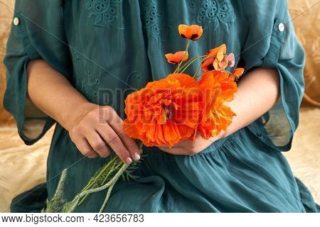 Woman In Green Dress Holding Poppe Flowers, Close Up On Her Hands. Spring Time Dreams.