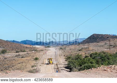 Baartmansfontein, South Africa - April 7, 2021: A Grader Working On The Road Between Seweweekspoort 