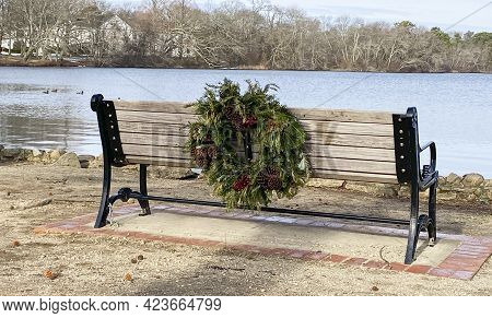 A Bench Facing The Lake At Belmond State Park With A Christmas Wreath Placed On The Back For The Hol