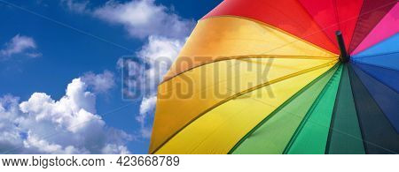 Summer Concept. Good Weather Concept. Colors Of Rainbow. Colorful Umbrella Rainbow Colors On Blue Sk