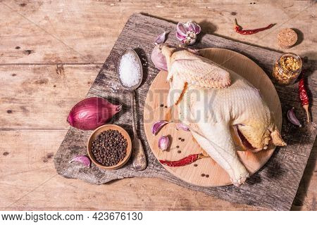 Raw Whole Chicken Carcass For Healthy Food Lifestyle With Red Onion, Garlic Cloves, Spices, And Sea