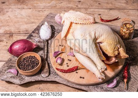 Raw Whole Chicken Carcass For Healthy Food Lifestyle With Red Onion, Garlic Cloves, Spices, And Sea