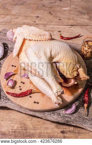 Raw Whole Chicken Carcass For Healthy Food Lifestyle With Red Onion, Garlic Cloves, Spices, And Sea