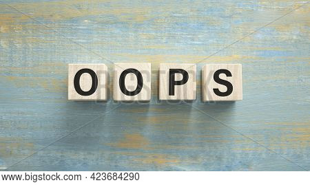 Word Oops. Wooden Small Cubes With Letters Isolated On Blue Background With Copy Space Available. Co