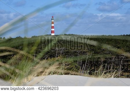 Classic, Historic Old Red And White Lighthouse With Dunes And Grass, Sunny Windy Day And Turbulent C