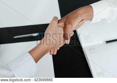 Photo Of Female Hands. Businessmen Conclude An Agreement Shaking Hands Over The Table
