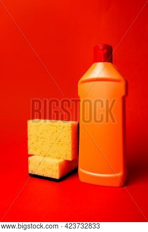 Yellow Sponge And Orange Bottle With Cleaning On A Red Background