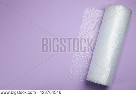Bubble Wrap Roll On Lilac Background, Top View. Space For Text