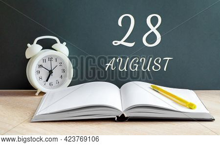 August 28. 28-th Day Of The Month, Calendar Date.a White Alarm Clock, An Open Notebook With Blank Pa
