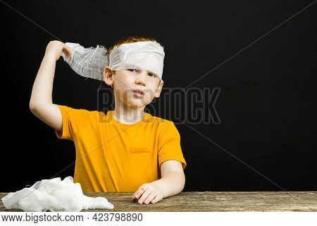 A Beautiful Boy With Red Hair With A Damaged Hand And Fingers Bandages Himself With A Medical Bandag