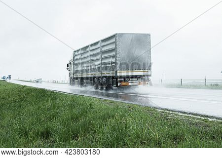 The Movement Of Trucks Of Trucks With A Semi-trailer And Cars On A Wet Road In Rain And Fog And In P