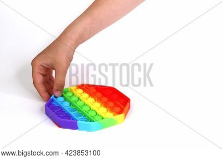 Anonymous Child With Colorful Poppit Game. Close Up Bunner Shot Of Kid Hands Playing With Colorful P