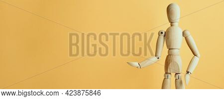 Wooden Doll With Gesture On Yellow Background. Mannequin Shows Gesture. Figure Of Wooden Human With 