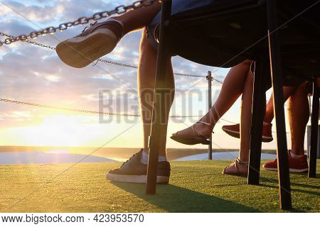 Close-up Of Crossed Legs Of Young People Sitting