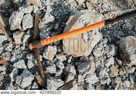 Pickaxe Hoe Lying On Crushed Stones. Hand-held Percussion Tool Designed For Working On Stone, Stony 