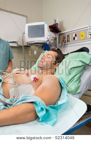 Male patient with holter monitor stuck to chest in hospital