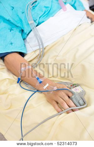 Pulse oximeter attached to male patient's finger in hospital