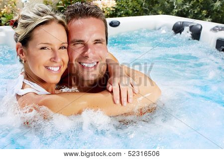 Happy couple relaxing in hot tub. Vacation.