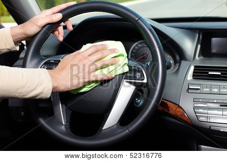 Hand with microfiber cloth cleaning car.