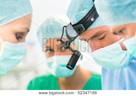 Hospital - surgery team in the operating room or Op of a clinic operating on a patient, perhaps it's an emergency